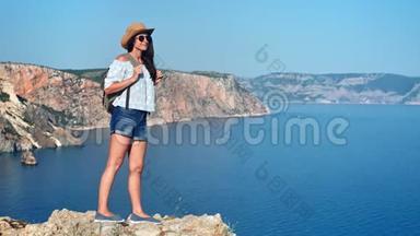 迷人的旅行背包客女人<strong>站在山顶</strong>欣赏美丽的海洋景观